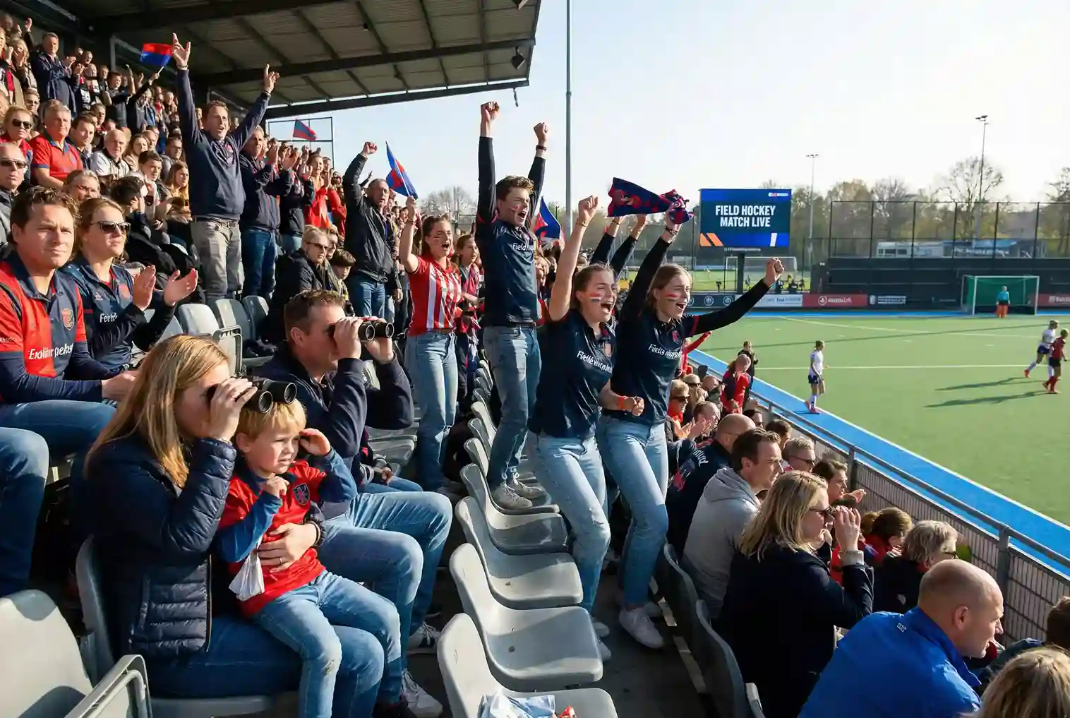 Hockeyfans in het stadion genieten van de wedstrijd