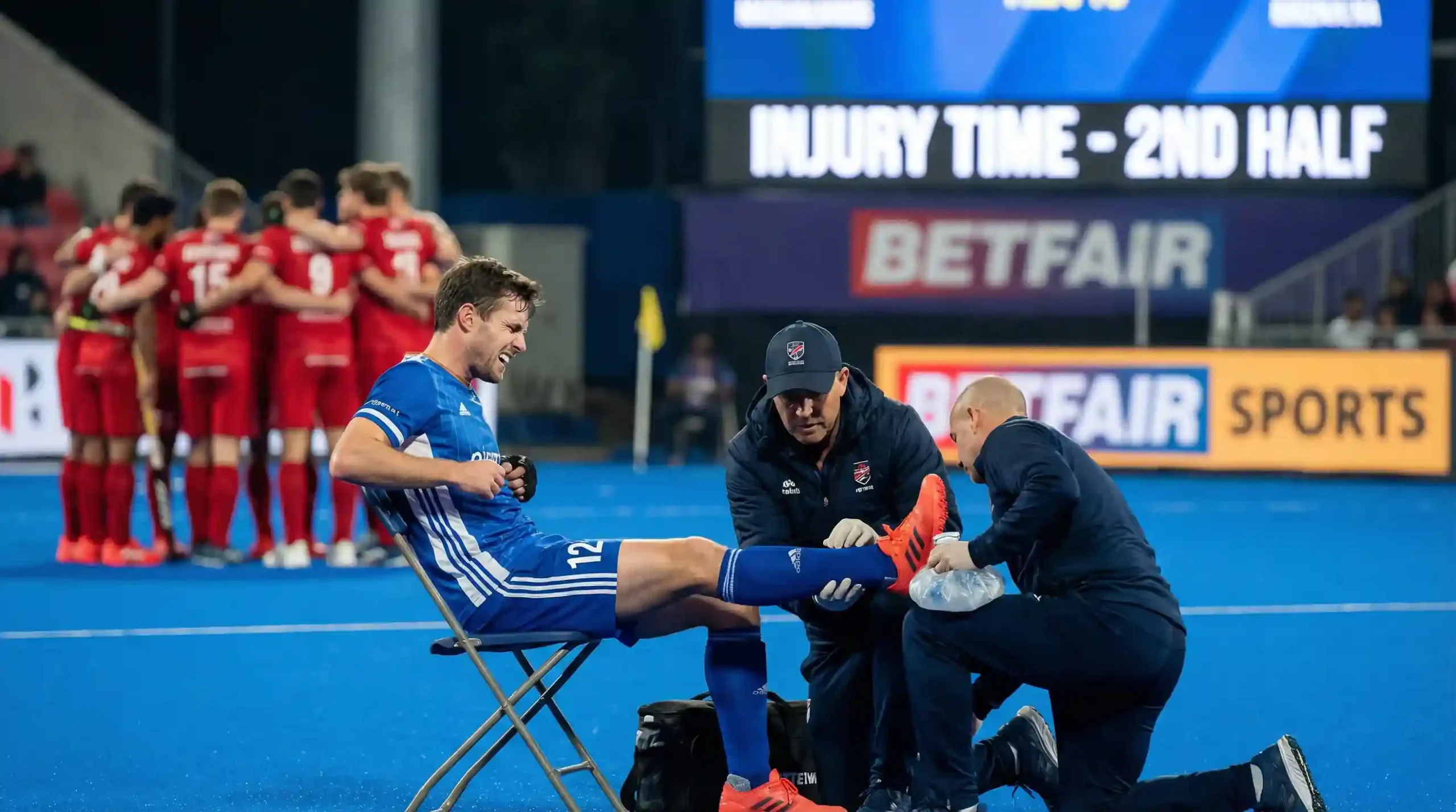 Hockeyspeler krijgt medische behandeling langs de zijlijn