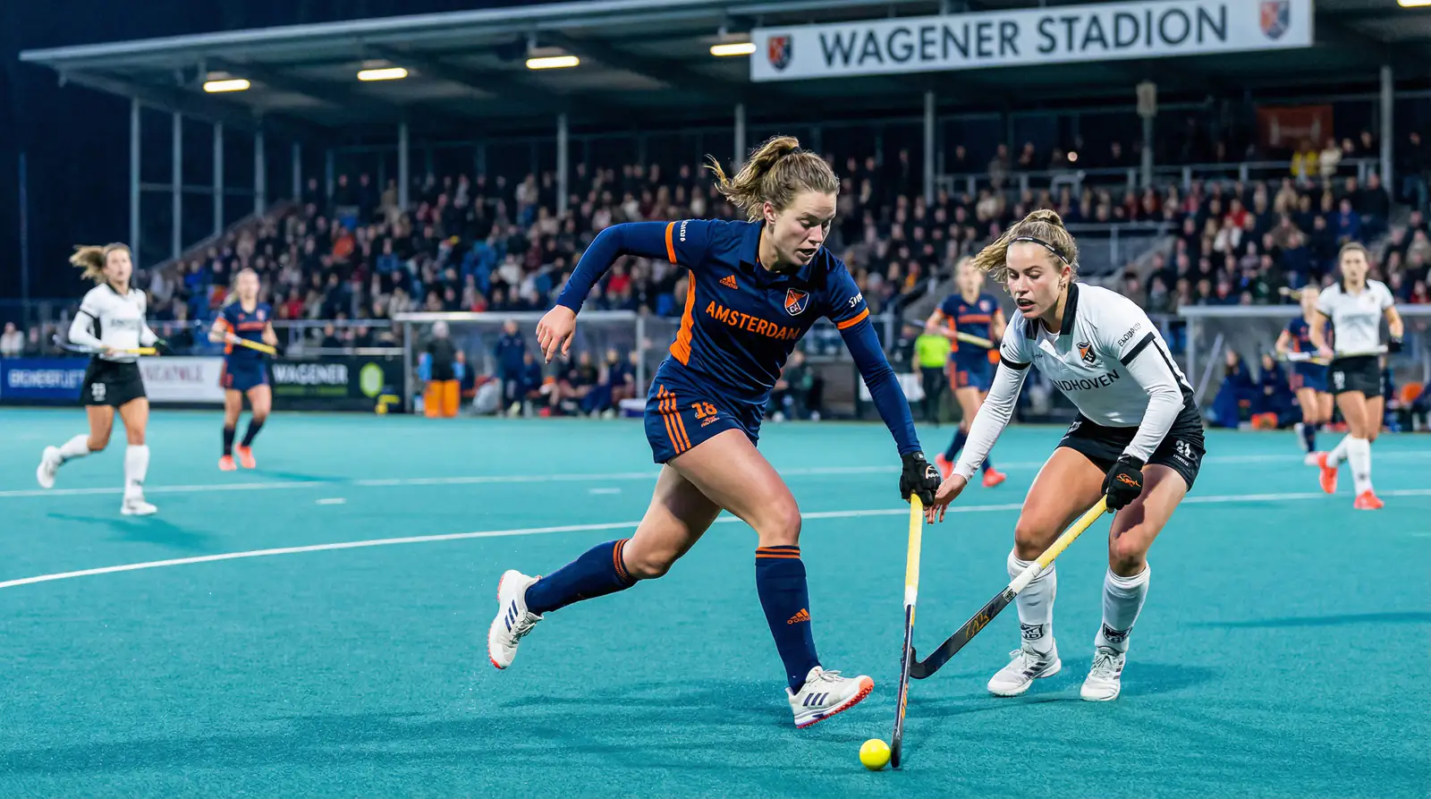 Vrouwelijke hockeyspelers in actie tijdens een Hoofdklasse wedstrijd