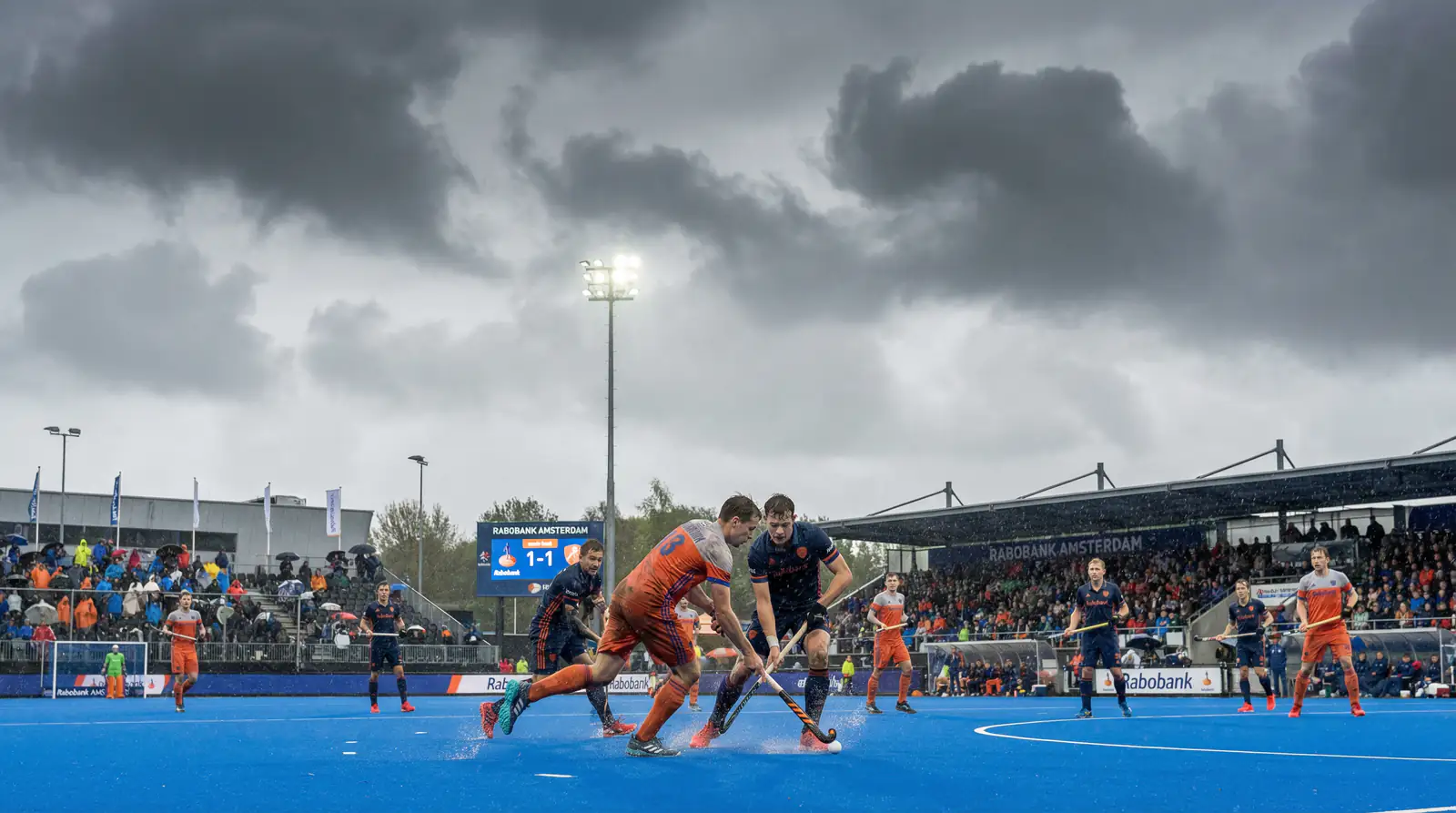 Hockeywedstrijd onder wisselende weersomstandigheden